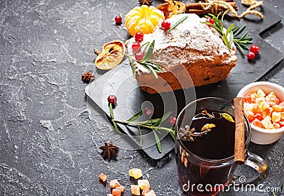 Hot mulled wine for winter and Christmas cake with delicious on black stone background Stock Photo