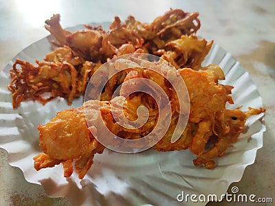 Hot onion bhajjiya bhajiya Indian fast food street food with green pudina chutney on paper plate ready to eat yummy tastey food Stock Photo