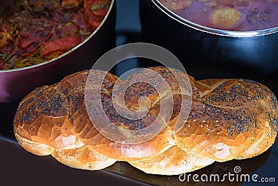 Hot plate for Sabbath with traditional food for Shabbat cholent and challah-special bread in Jewish cuisine.Top view. Stock Photo