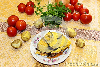 Hot ready moussaka is served on a porcelain plate among vegetables and spicy herbs. Fresh vegetables for cooking light dinner, Mo Stock Photo