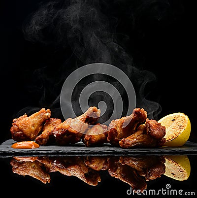 Hot and spicy bbq chicken wings with dip and hot sauce on black stone plate Stock Photo