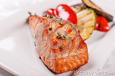 Hot and spicy fillet red fish. Grilled steak salmon or trout with grill paprika and zucchini. Healthy food, seafood and Stock Photo