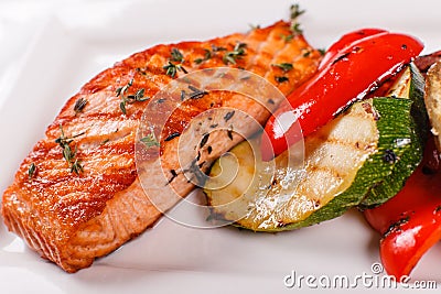 Hot and spicy fillet red fish. Grilled steak salmon or trout with grill paprika and zucchini. Healthy food, seafood and Stock Photo