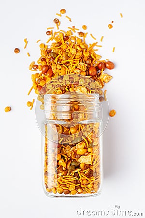 Hot spicy Nav Ratan snacks spilled out and in a glass jar, made with red chili, peanuts, corn flakes. Stock Photo