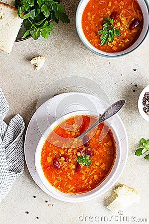 Hot and spicy, thick lentil and red bean soup with canned tomatoes and coriander. Concrete background. Top view Stock Photo