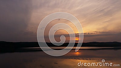 Hot sunset above the forest. Refelctions of red clouds in the water of the lake. bright colors at the end of a summer day Stock Photo