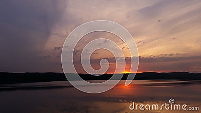 Hot sunset above the forest. Refelctions of red clouds in the water of the lake. bright colors at the end of a summer day Stock Photo