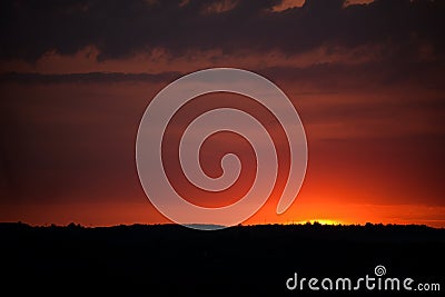 Hot sunset above the forest. Refelctions of red clouds in the water of the lake. bright colors at the end of a summer day Stock Photo