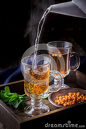 Hot tea flowing in glass cup with berries. Stock Photo