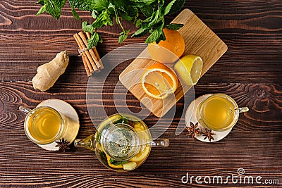 Hot tea with lemon, orange, ginger and mint on wooden table in the morning Stock Photo