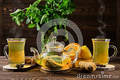 Hot tea with lemon, orange, ginger and mint on wooden table in the morning Stock Photo