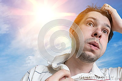 Hot weather concept. Young man is sweating. Sun in background Stock Photo