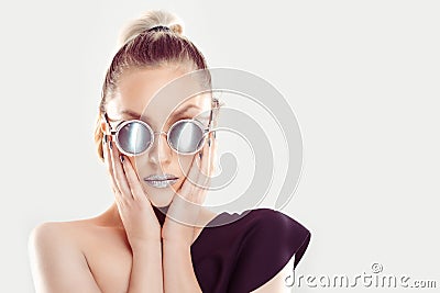 Hot woman with gray glasses hands on cheeks combined in set with grey metallic shiny mirror nails and lips and sunglasses Stock Photo