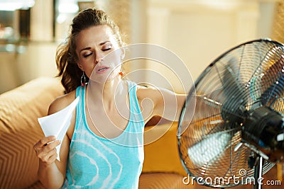 Hot woman in front of working fan suffering from summer heat Stock Photo