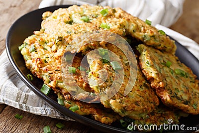 Hot Zucchini Fritters with green onions on a plate close-up. horizontal Stock Photo