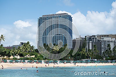 Hotel oceanfront on a sunny white sand beach on Waikiki Honolulu in Hawaii with tourist and beach goer enjoying water outdoor acti Editorial Stock Photo