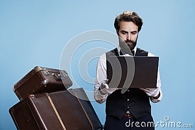 Hotel porter in suit using laptop Stock Photo