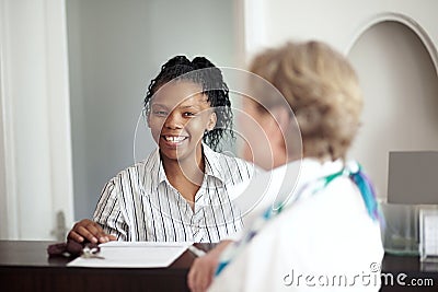 Hotel receptionist, concierge and a black woman helping a senior tourist to check in at a luxury resort. Hospitality Stock Photo