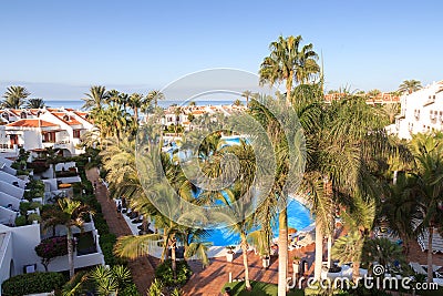 Hotel resort panorama with swimming pool, palm trees and view of the Atlantic Ocean in Playa de las Americas, Tenerife Stock Photo