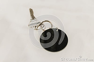 Hotel room key with round black blank pendant white background Stock Photo