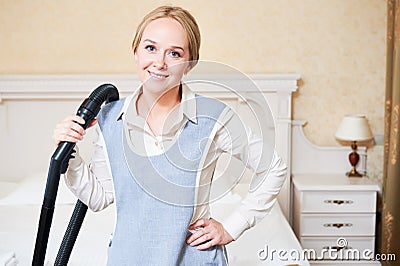 Hotel service. female housekeeping worker with vacuum cleaner Stock Photo