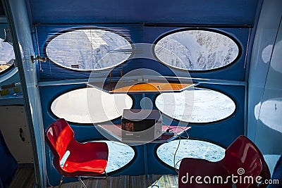 Hotel in the shape of an alien flying saucer standing high in the mountains among the snow capped mountain peaks. Dombay Editorial Stock Photo