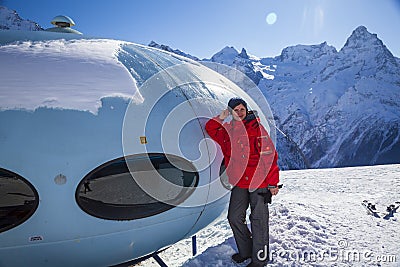 Hotel in the shape of an alien flying saucer standing high in the mountains among the snow capped mountain peaks. Dombay Editorial Stock Photo