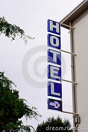 Hotel sign text blue and arrow in wall building facade in french tourist city Stock Photo