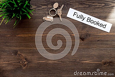 At the hotel. Words fully booked on dark wooden table top view copyspace Stock Photo