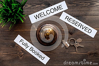 At the hotel. Words welcome, fully booked, reserved on dark wooden table top view Stock Photo