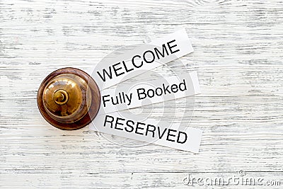 At the hotel. Words welcome, fully booked, reserved on light wooden table top view copyspace Stock Photo