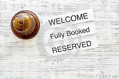 At the hotel. Words welcome, fully booked, reserved on light wooden table top view copyspace Stock Photo