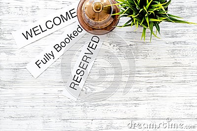 At the hotel. Words welcome, fully booked, reserved on light wooden table top view copyspace Stock Photo