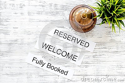 At the hotel. Words welcome, fully booked, reserved on light wooden table top view copyspace Stock Photo