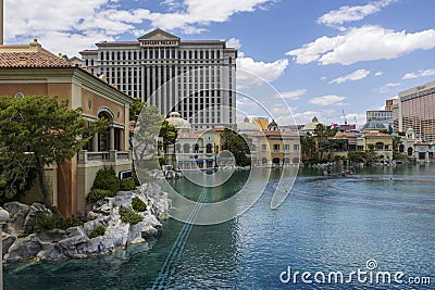 hotels , tower cranes and a Ferris wheel in the city skyline with a lake surrounded by lush green trees and people walking Editorial Stock Photo