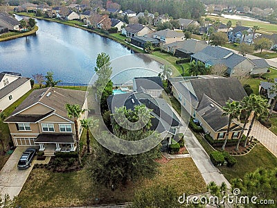 Houes and Screen Porches Line the Bank of a Small Pond in an American Neighborhood from Above Aerial Stock Photo