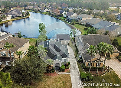 Houes and Screen Porches Line the Bank of a Small Pond in an American Neighborhood from Above Aerial Stock Photo