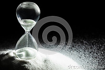 Hourglass add more sand of time on white sand over black background. White hourglass show more time Deadline extended time Stock Photo