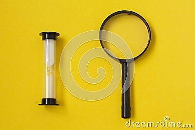 Hourglass as a concept of passing time for business term, urgency and outcome of time with a magnifying glass Stock Photo