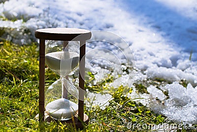 Hourglass as a symbol of changing of the seasons. Spring is coming Stock Photo