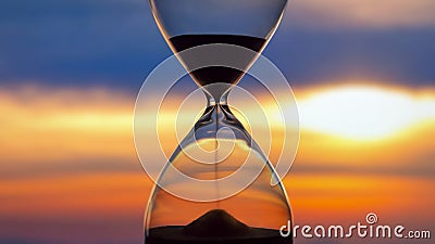 Hourglass on the background of a sunset. The value of time in life. An eternity Stock Photo
