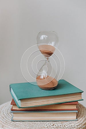 Hourglass flask retro stand stack books measuring Stock Photo