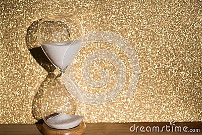 Hourglass, gold colored background Stock Photo