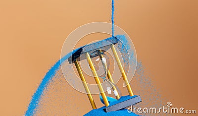 Hourglass is money sand of time, business pouring blue sand into hourglass to add more time in financial. Deadline extended time Stock Photo