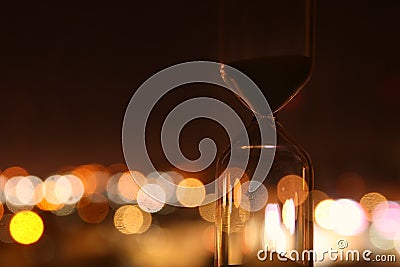 Hourglass over bokeh city lights as time passing concept for business deadline. Stock Photo