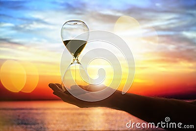 Hourglass at sunset concept for time passing Stock Photo