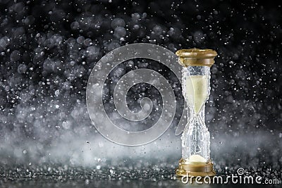 Hourglass under the water drops on black background. Time limited. Deadline. Marketing strategy. Stock Photo