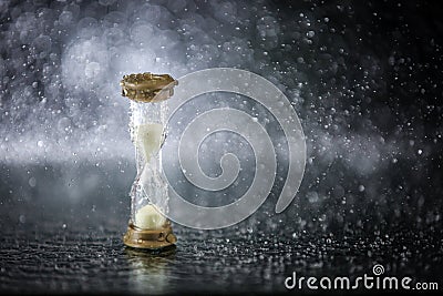 Hourglass under the water drops isolated on black background. Time limited. Deadline. Marketing strategy. Stock Photo