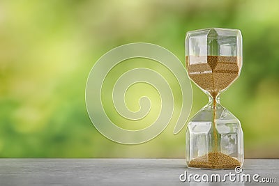 Hourglass on wooden table outdoors. Time management concept Stock Photo