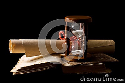 Hourglasses and book On black Stock Photo